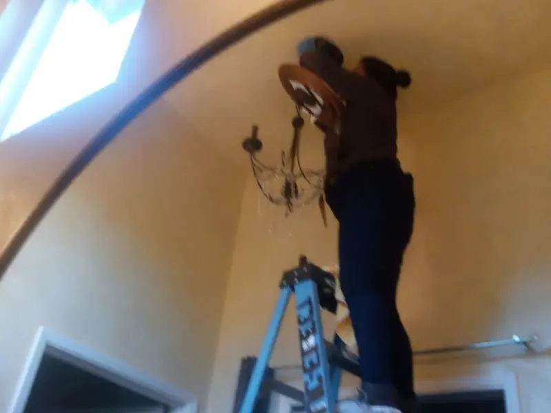 Electrician installing a chandelier in a East Bay residence